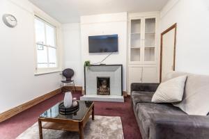 uma sala de estar com um sofá e uma lareira em May Disc - Long Stay - Contractors em Swindon