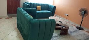 a green couch in a living room with a table at One bedroom panthehouse in Kisumu