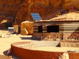 Wadi rum view camp في وادي رم: منزل عليه لوحة شمسية