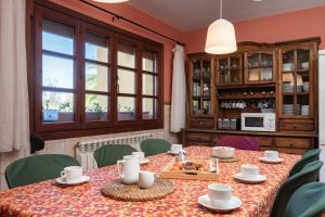 ein Esszimmer mit einem Tisch, Stühlen und einem Fenster in der Unterkunft Casa ideal para familia en Ribadesella Africa in Cuerres
