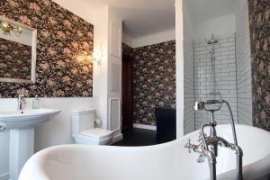 La salle de bains est pourvue d'une baignoire, d'un lavabo et de toilettes. dans l'établissement Suite Georg Anno 1869 HERRENHAUS VIECHELN, à Behren-Lübchin