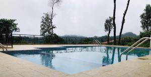 a swimming pool with a mountain in the background at Mothers Bounty by Lazo , Coorg in Madikeri