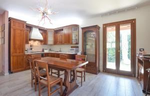 een keuken met houten kasten en een tafel en stoelen bij Lovely Home In Modica With Kitchen in Modica