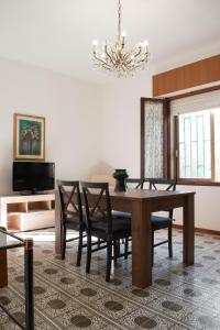 une salle à manger avec une table, des chaises et un lustre dans l'établissement Casa Doré in South Sardinia, à Sìnnai