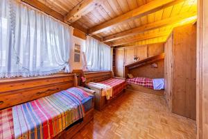 1 dormitorio con 2 camas en una casa de madera en Villa Pais 3 cime View en Auronzo di Cadore