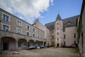 un gran edificio de piedra con un patio adoquinado en Château de Beaugency, Suite La Voute, en Beaugency