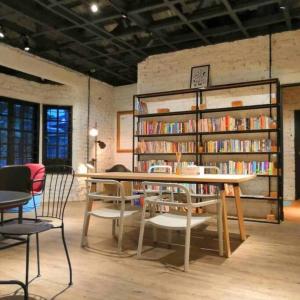 una stanza con biblioteca con tavolo e sedie di Books & Beds a Petaling Jaya