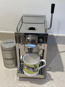 a coffee maker with a coffee mug in it at Masons Cottage, an Idyllic retreat in an area of outstanding beauty, close to Blenheim Palace, Oxford & The Cotswolds in Stonesfield