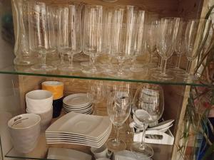 ein Glasregal mit Gläsern, Tellern und Geschirr in der Unterkunft Naturparadies in Marktl