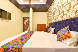 a bedroom with a large white bed with colorful pillows at FabHotel Spark in Jaipur