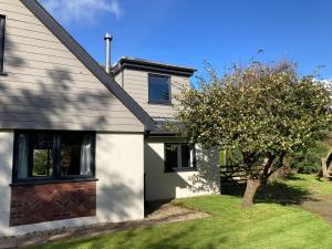 a white house with a tree in front of it at The Annex, Escape to the Country in Salcombe