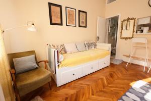 a bedroom with a bed and a chair in it at Studio Jasna in Novi Sad