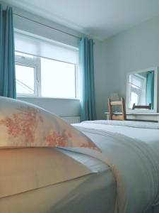 a bedroom with a white bed with a window at Castlebar 3 bedroom house in Castlebar
