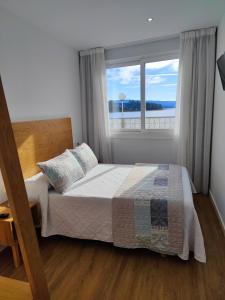 A bed or beds in a room at Apartamentos La Toja