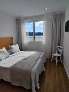 A bed or beds in a room at Apartamentos La Toja