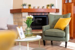 una sala de estar con una silla verde y un jarrón con flores en Monte Balaton, en Paloznak