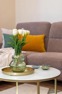 a vase with flowers on a table in a living room at Monte Balaton in Paloznak