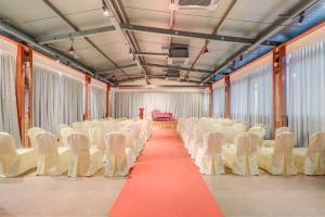 pusty pokój z białymi krzesłami i czerwonym dywanem w obiekcie HARI GOVINDA'S w mieście Mysuru