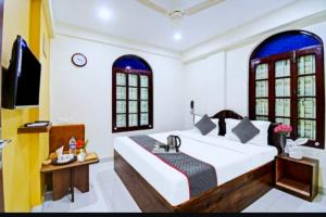 - une chambre avec un grand lit et un lavabo dans l'établissement Hotel Jheel Mahal New Town Inn West Bengal - Couple Friendly, à Jojera