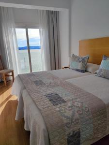 A bed or beds in a room at Apartamentos La Toja