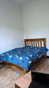 1 dormitorio con 1 cama y mesa con ordenador portátil en Mwacha_Farm_house, en Moshi