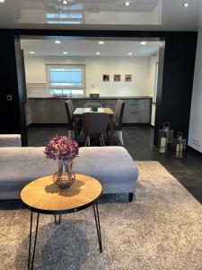 a living room with a table with a vase of flowers at Alex Design Appartment in Rastatt