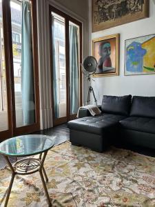 波多的住宿－Nasoni Porto Apartment，客厅配有黑色沙发和玻璃桌