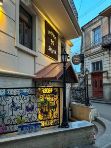 a shop with a sign on the side of a building at Silver 39 Corner Hotel in Tbilisi City