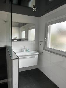 a white bathroom with a sink and a window at Alex Design Appartment in Rastatt