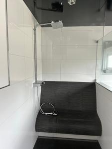 a black bench in a room with a shower at Alex Design Appartment in Rastatt