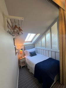 a small bedroom with a bed and a window at Y Stabl in New Quay