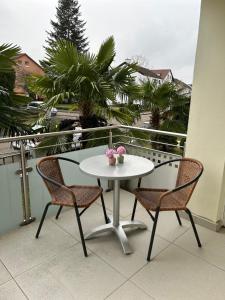 拉施塔特的住宿－Alex Design Appartment，阳台上配有一张白色的桌子和两把椅子
