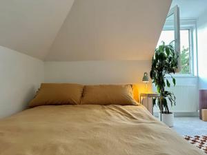 um quarto com uma cama, uma planta e uma janela em Designer 2 bedroom flat with office em Londres