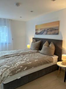 a bed in a bedroom with a painting on the wall at Alex Design Appartment in Rastatt