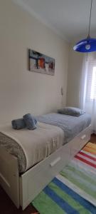 1 dormitorio con 2 camas y alfombra colorida en Casa da Avó Isaura - Ericeira, en Ericeira
