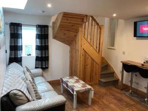 Mc Courts Barn, Tiny house in the Mournes في Hilltown: غرفة معيشة مع أريكة وباب خشبي +47 صورة