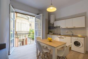 a kitchen with a table and chairs and a window at Cathedral Suites in Málaga