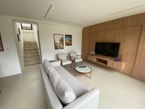 sala de estar con sofá y TV en Refúgio em Condomínio- Flecheiras en Trairi