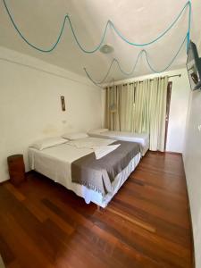 a bedroom with two beds and a blue banner on the ceiling at POUSADA TAIEIRAS in Maragogi +19 photos