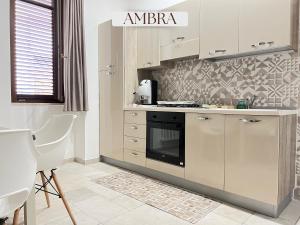 a kitchen with white cabinets and a stove at Residence Lori in Brindisi