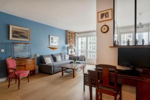 a living room with a couch and a tv at Eiffel Tower Elegant Residence in Paris