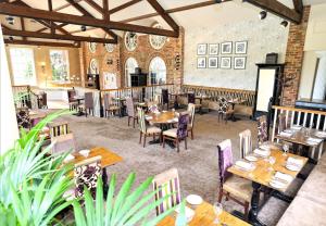 a restaurant with tables and chairs in a room at The Bridge Hotel and Spa in Wetherby