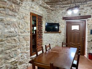 a dining room with a wooden table and a stone wall at Il Casale - tra Passato e Modernità 