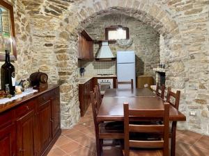 a kitchen with a table and a stone wall at Il Casale - tra Passato e Modernità 