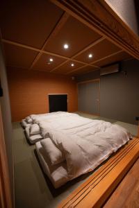 a large bed with white sheets in a room at 横川温泉湯殿ととのゆ in Shimoda