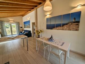 un soggiorno con tavolo e sedie bianchi di Luxury Country Villa by SardiniaGem, walk to beach a Orosei
