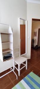 una sedia bianca seduta in una stanza con porta di Casa da Avó Isaura - Ericeira a Ericeira Altre 31 foto
