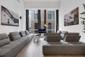 a living room with a couch and a tv at LiV MTL Downtown Montreal Spacious Suites in Montreal