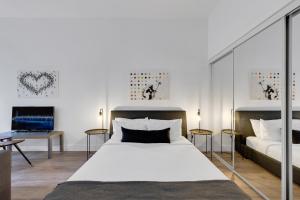 a bedroom with a large white bed and a tv at LiV MTL Downtown in Montréal +242 photos