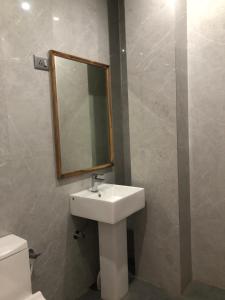 a bathroom with a sink and a mirror and a toilet at Anne’s Laces Homestay in Guwahati +2 photos